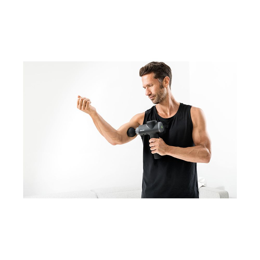 Ein Mann in einem schwarzen Tanktop benutzt eine Massagepistole an seinem Bizeps.