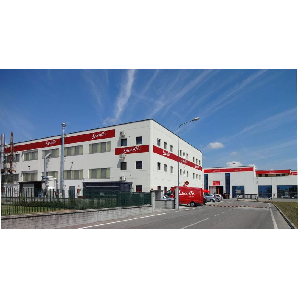 Ein weißes Gebäude mit roten Streifen und dem Logo "Luccaffè" unter einem blauen Himmel.