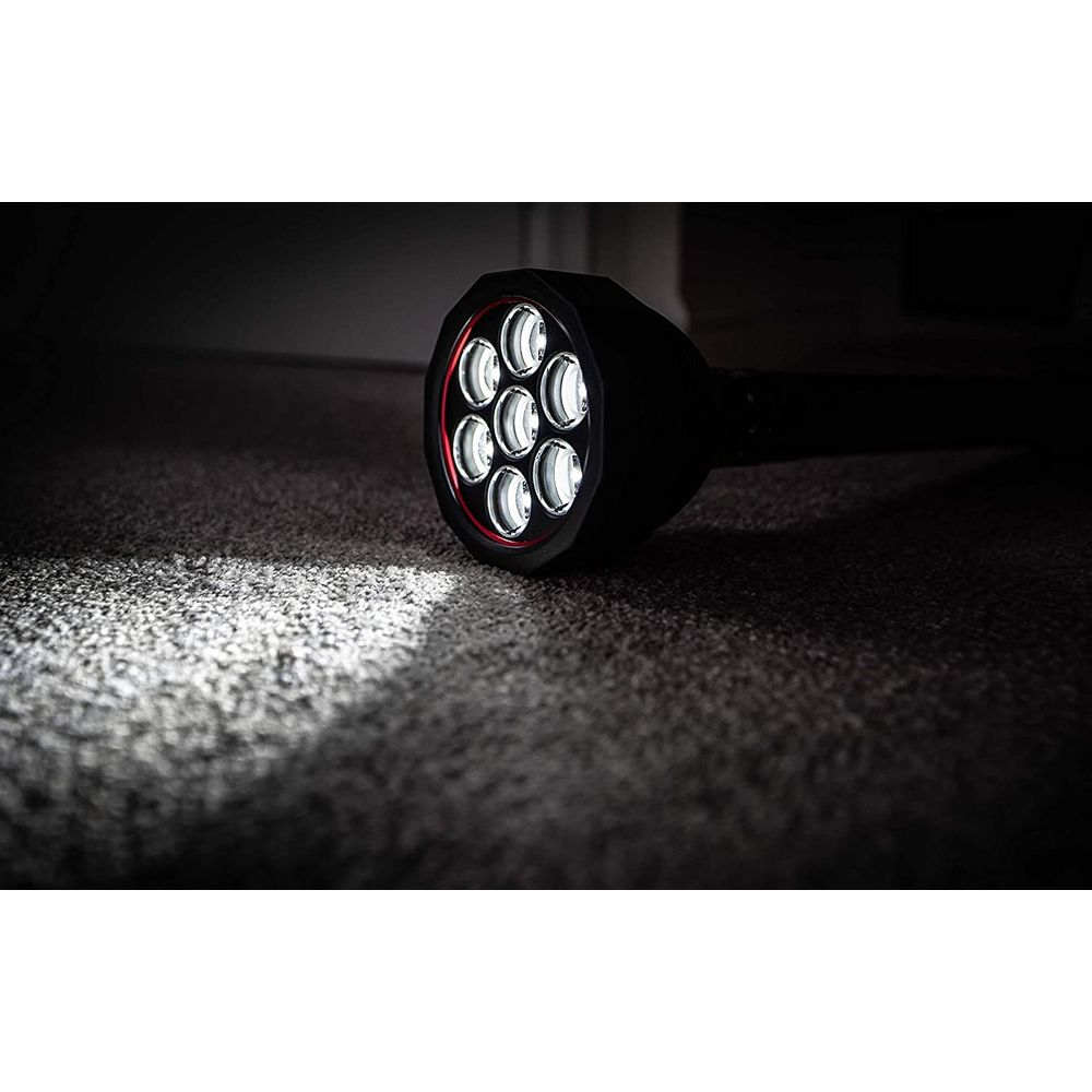 Ein schwarzer, heller Scheinwerfer mit sieben LEDs leuchtet auf einem Teppich.