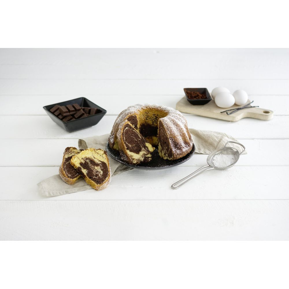 Marmor-Gugelhupf mit Puderzucker, Schokostückchen, Eiern und Vanille.