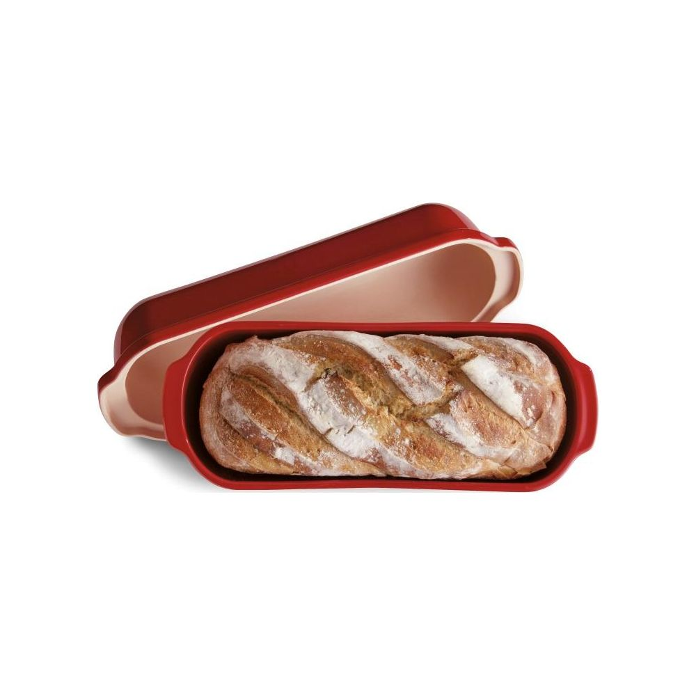 Ein Laib Brot mit Zopfmuster liegt in einer roten Brotbackform.