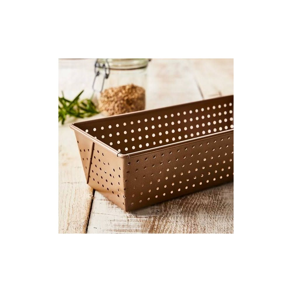 Eine bronzefarbene Lochblech-Backform steht auf einem Holztisch.