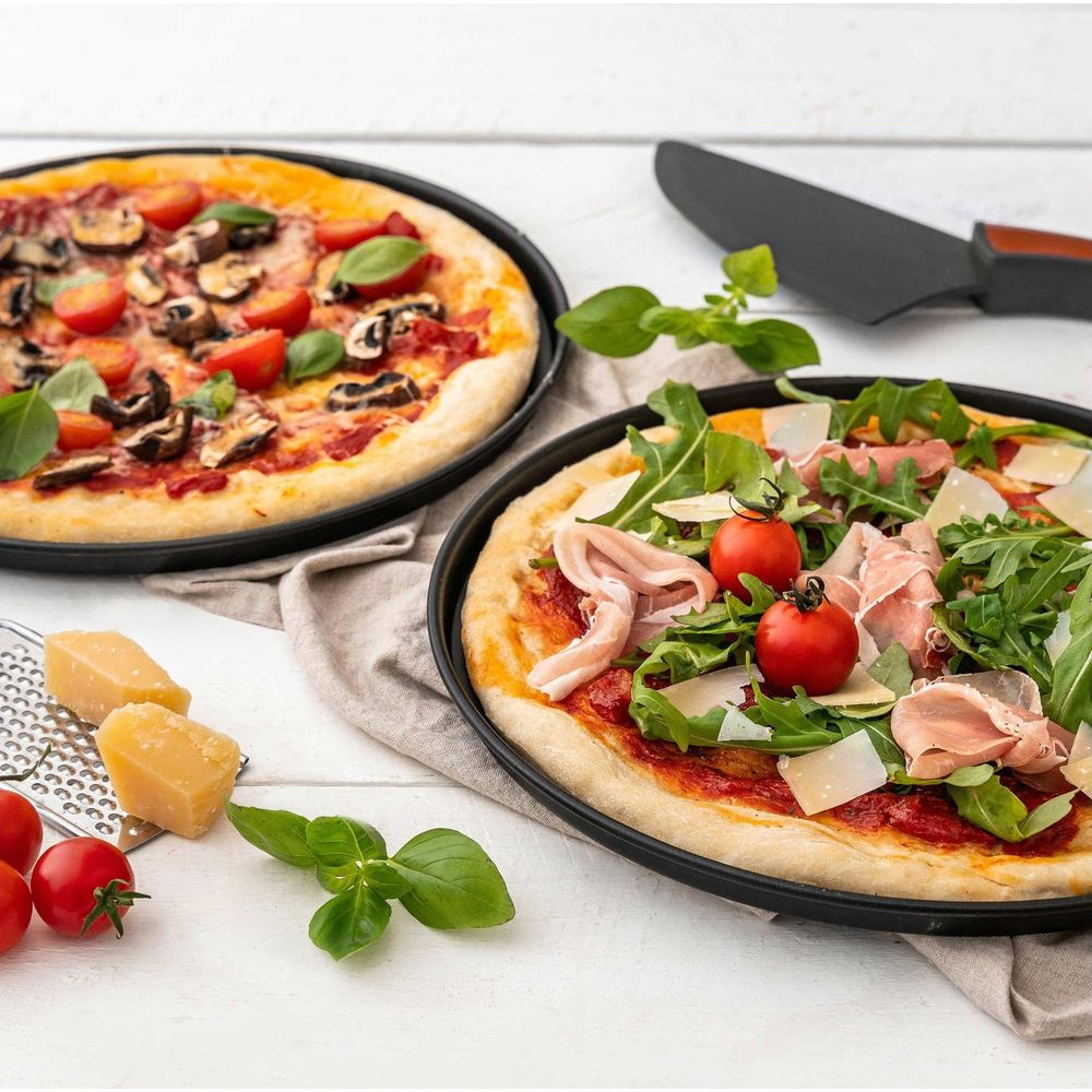 Zwei Pizzen, eine mit Pilzen und Tomaten, die andere mit Rucola und Schinken.