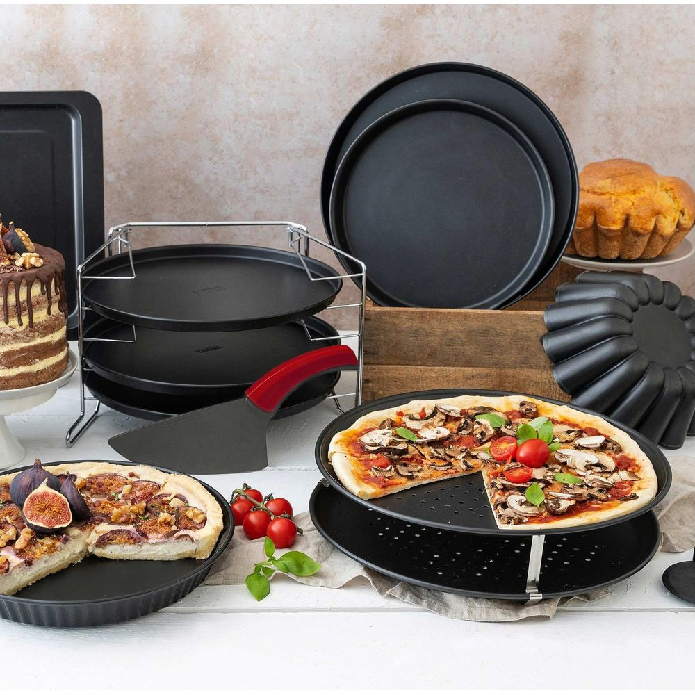 Backutensilien: Kuchen, Pizzen, Backbleche, Kuchenformen, Pizzaschaufel, auf Holzkiste.