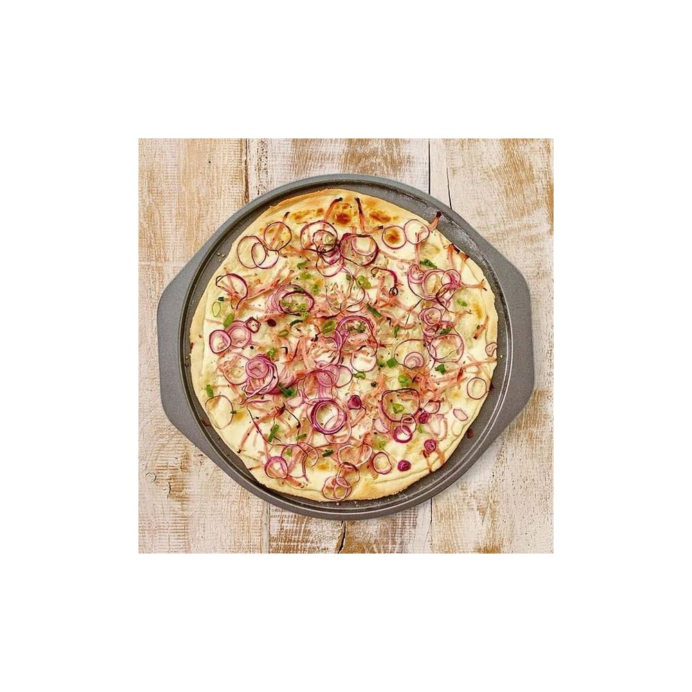 Eine runde Pizza mit weißen Zwiebeln und Kräutern auf einem Blech.