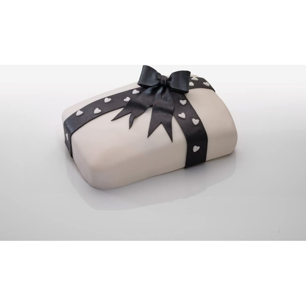 Ein weißer Kuchen mit schwarzer Schleife und Herzen, wie ein Geschenk verpackt.