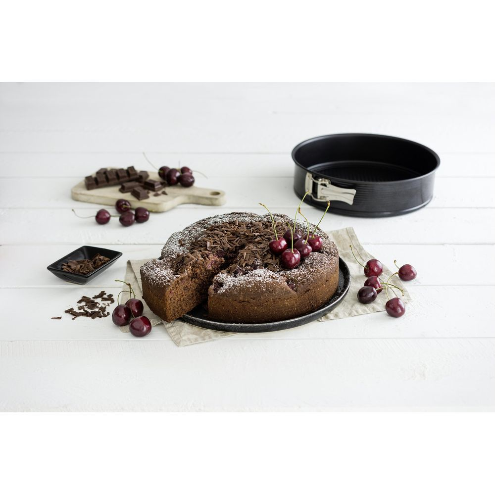Schokoladenkuchen mit Kirschen, Schokostückchen und einer Springform.