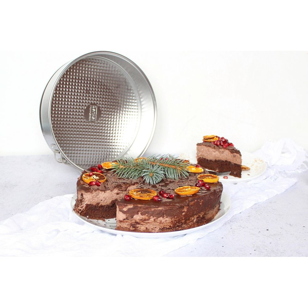 Schokoladenkuchen mit Orangenscheiben, Granatapfelkernen und Tannenzweigen.