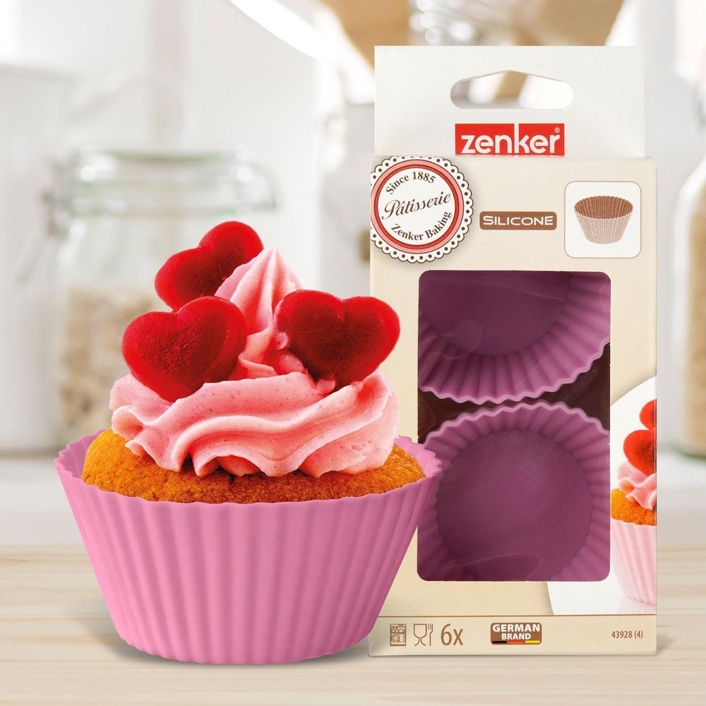 Eine rosafarbene Cupcake-Form aus Silikon mit rosa Zuckerguss und roten Herzspitzen.