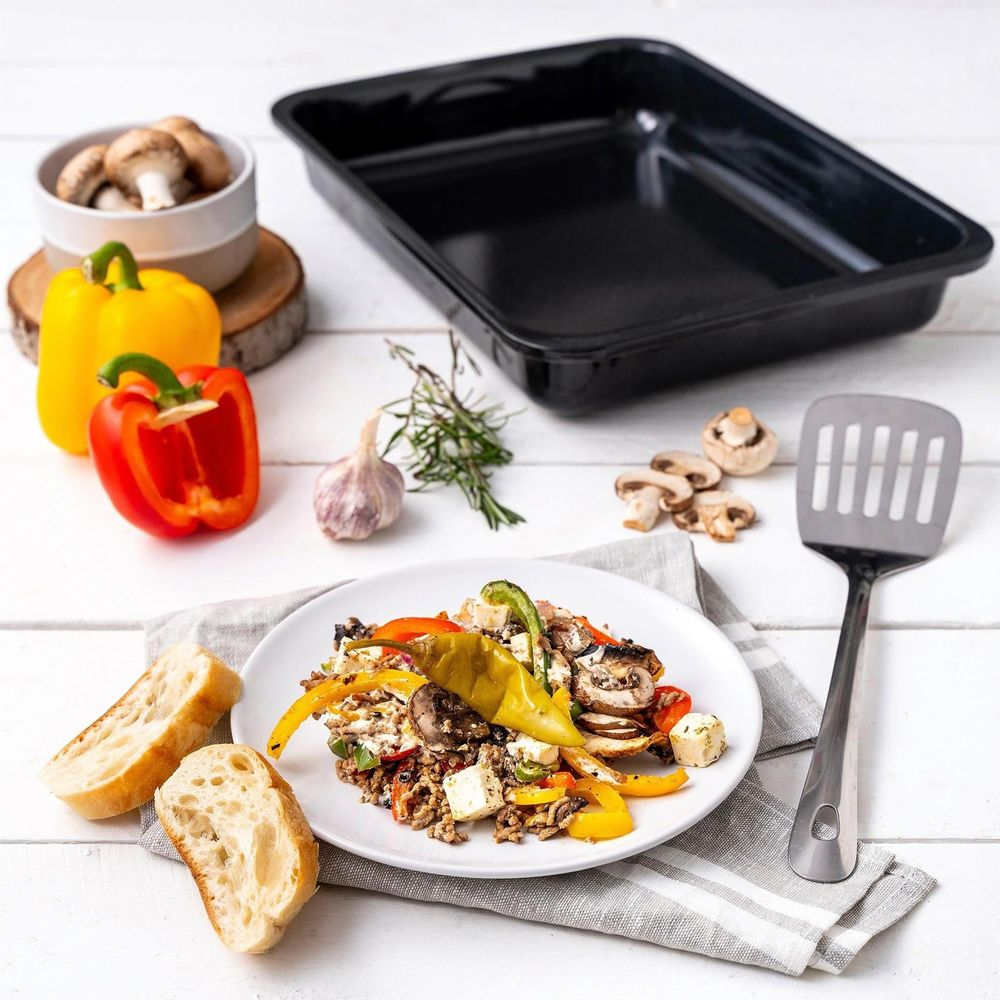 Gefüllte Paprika mit Käse, Pilzen und Brot auf einem Teller mit Kochutensilien.