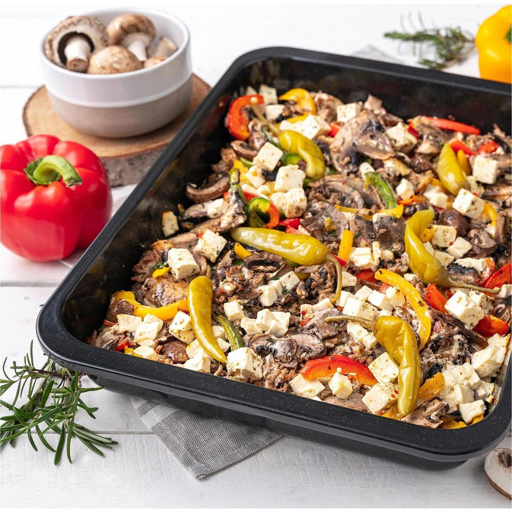 Auflauf mit Pilzen, Paprika, Käse und Peperoni in einer schwarzen Form.