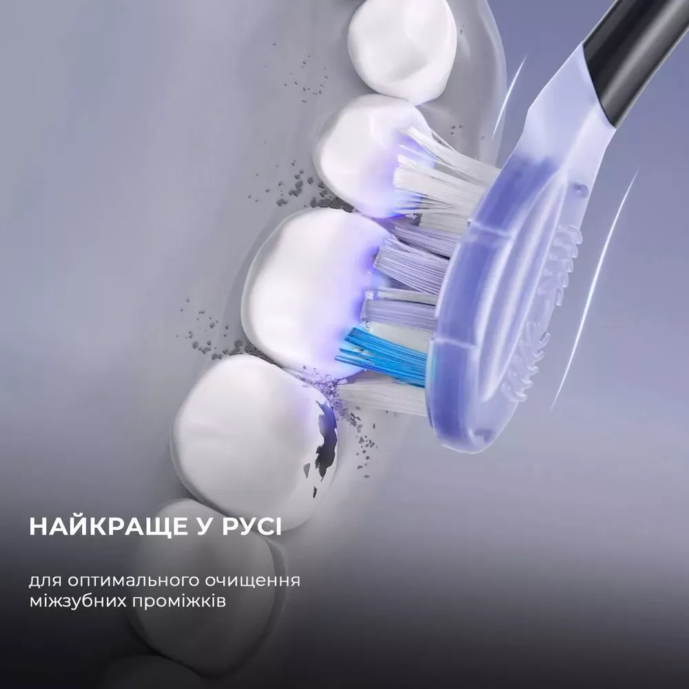 Toothbrush cleaning teeth with blue light and particles.