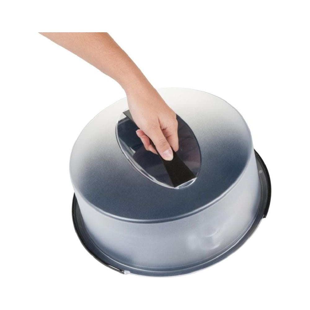 Une main saisit la poignée d'un porte-gâteau transparent.