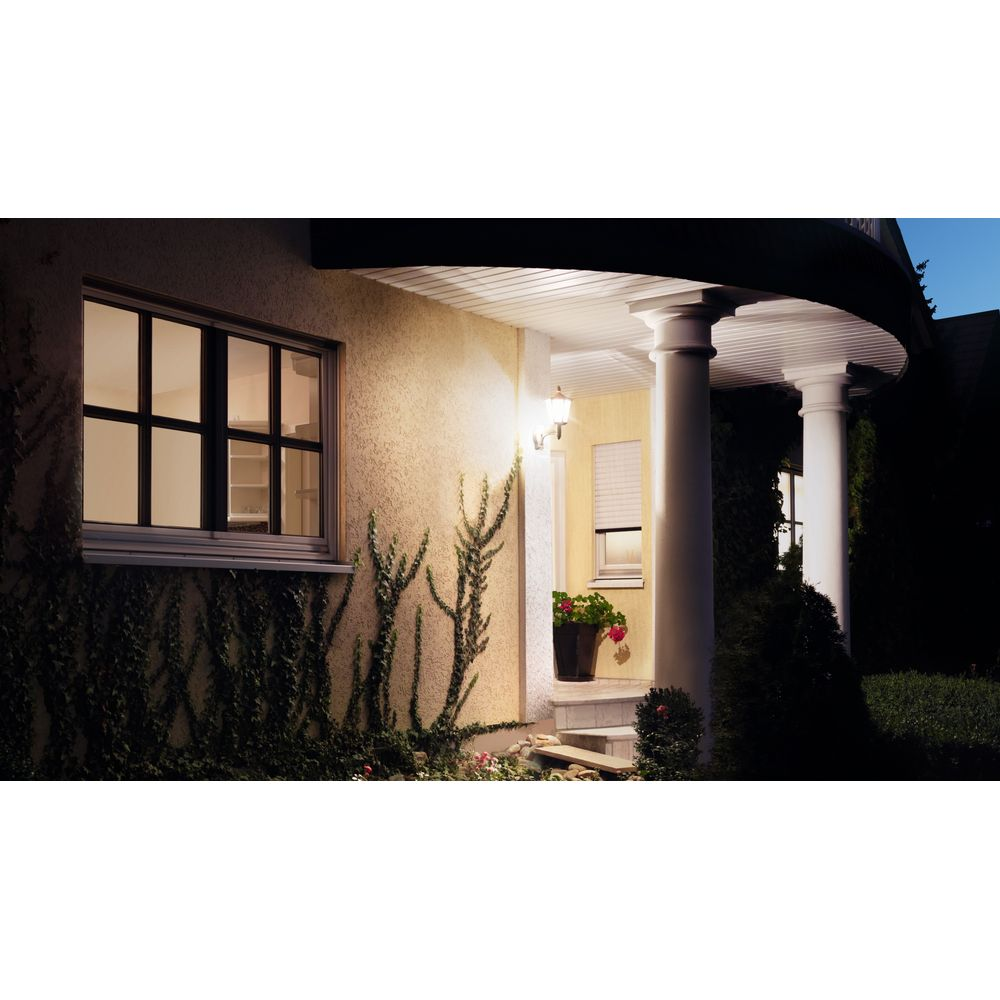 Hauswand mit Fenster und Säulengang, beleuchtet bei Nacht.
