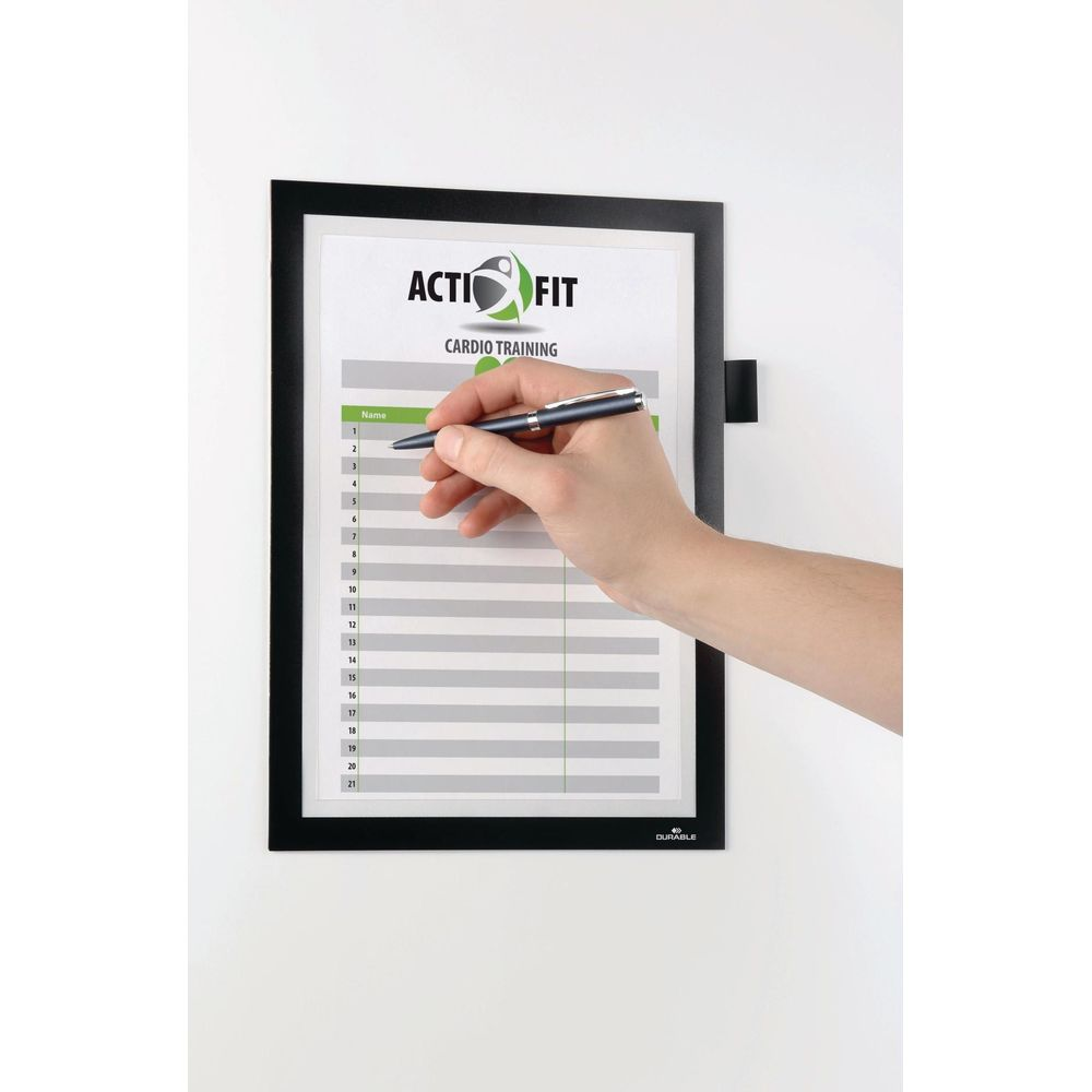 Hand schreibt auf eine Cardio-Trainingsliste mit Nummern und Namensfeldern.