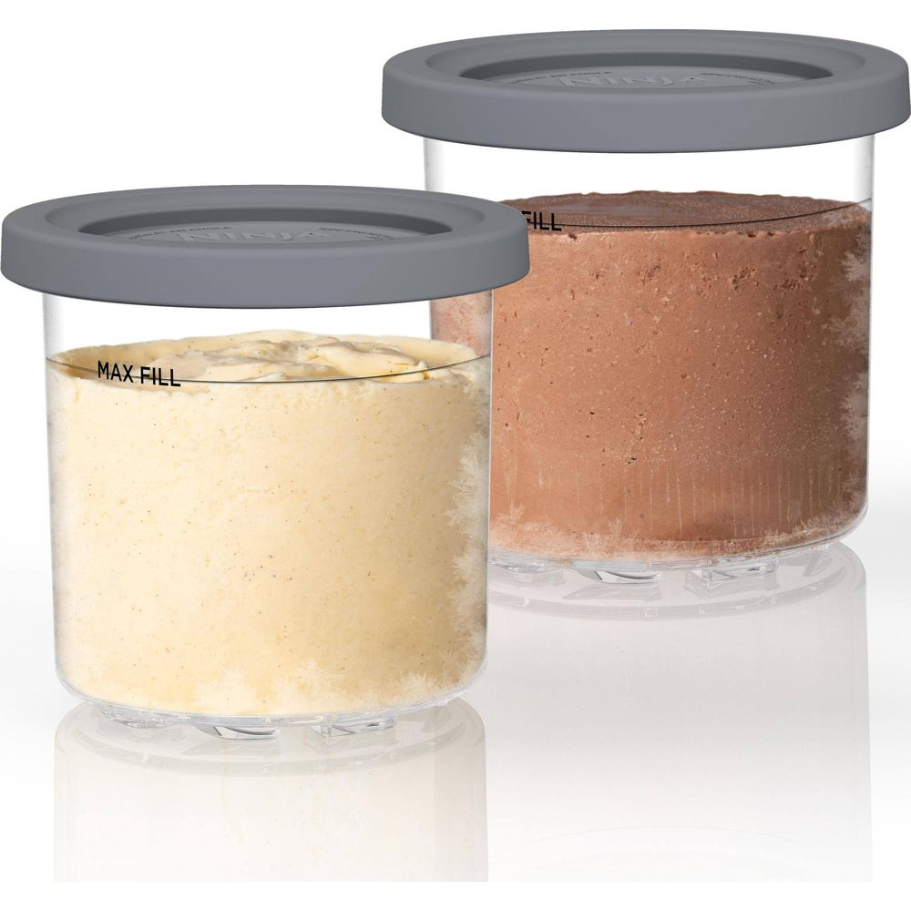 Due contenitori trasparenti con coperchi grigi, riempiti con purea chiara e scura.