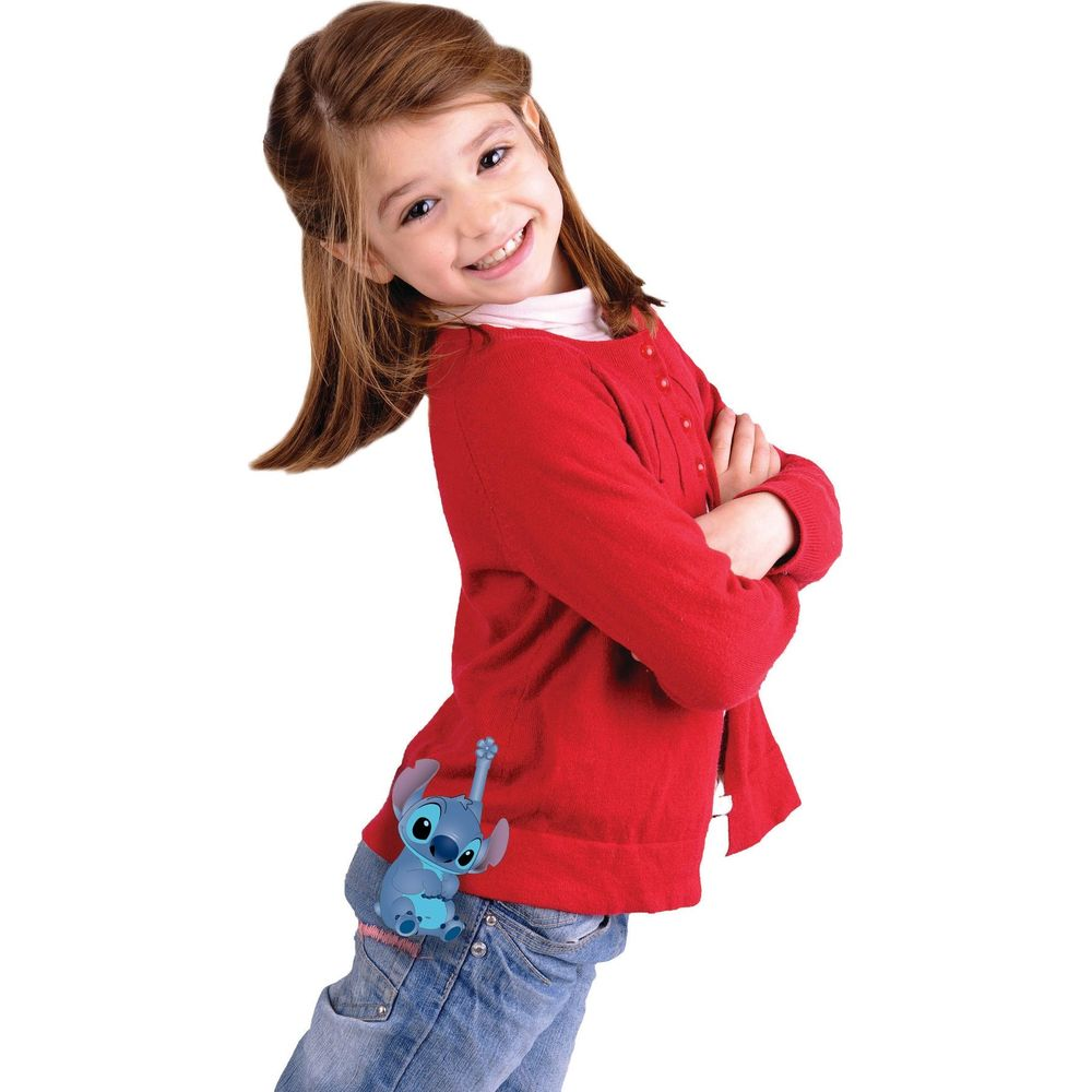 A girl in a red sweater and jeans smiles. Stitch is attached to her pants.