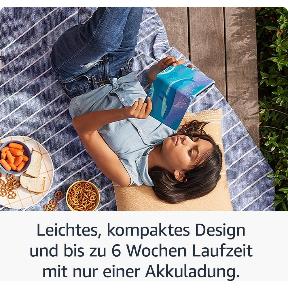 Mädchen liegt auf Decke und liest E-Reader mit Walmotiv.