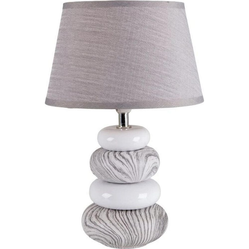 Eine Tischlampe mit einem grauen Lampenschirm und einem Sockel aus gestapelten Steinen.