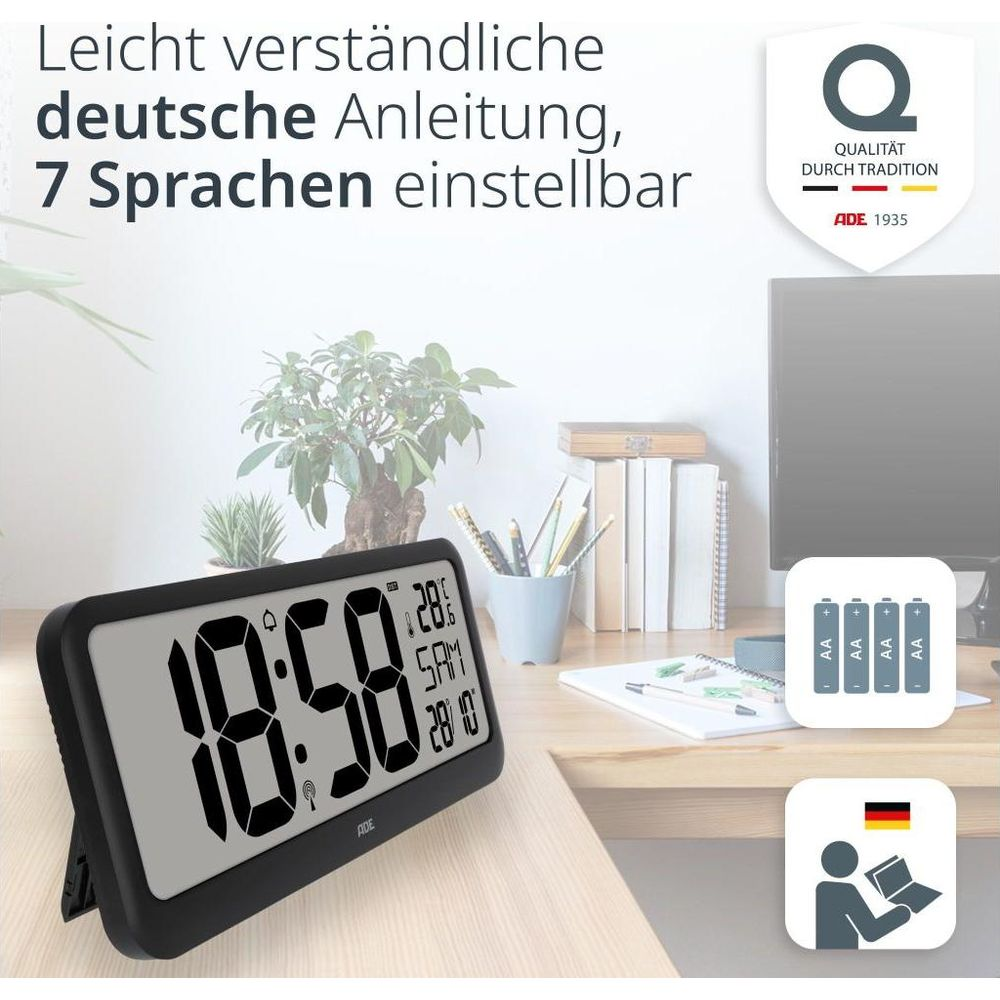 Digitaluhr mit Temperaturanzeige auf einem Schreibtisch neben Büromaterial.