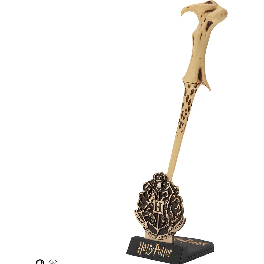 Una bacchetta con manico decorato e lo stemma di Hogwarts su un supporto.