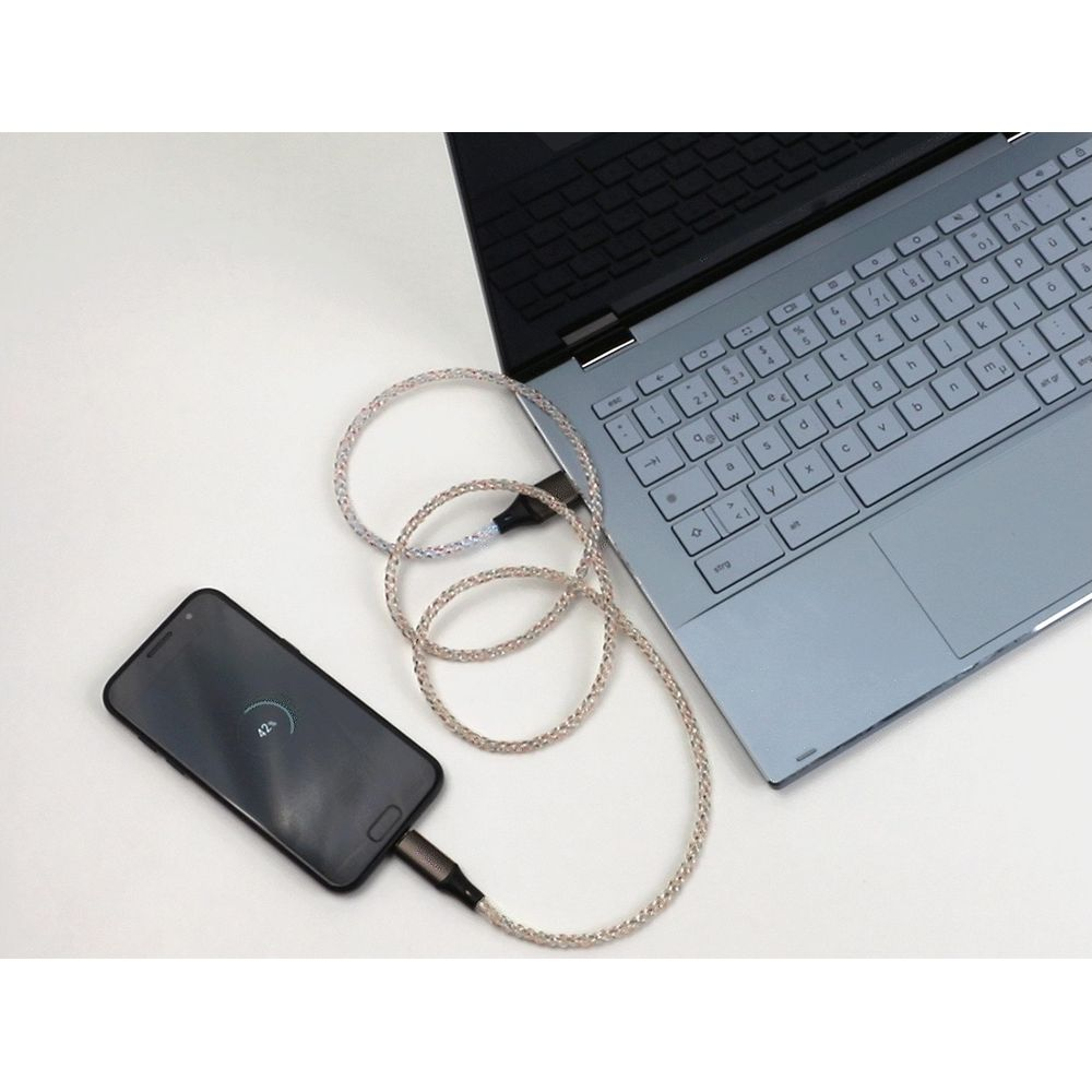 Un telefono si carica da un laptop tramite cavo trasparente.