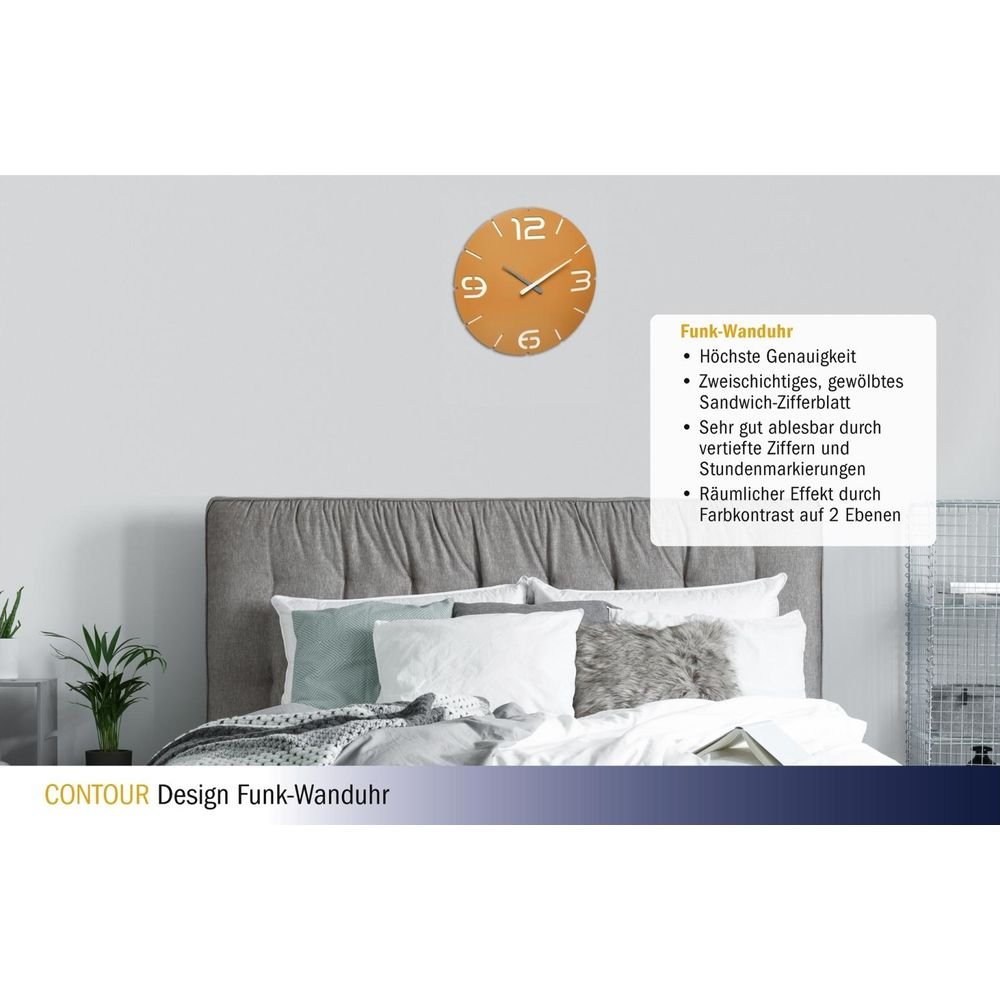 Eine orangefarbene Wanduhr mit weißen Ziffern hängt über einem Bett.