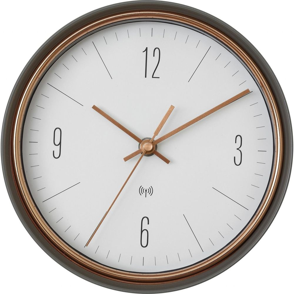 Eine Wanduhr mit weißem Zifferblatt, schwarzen Zahlen und Kupferzeigern.