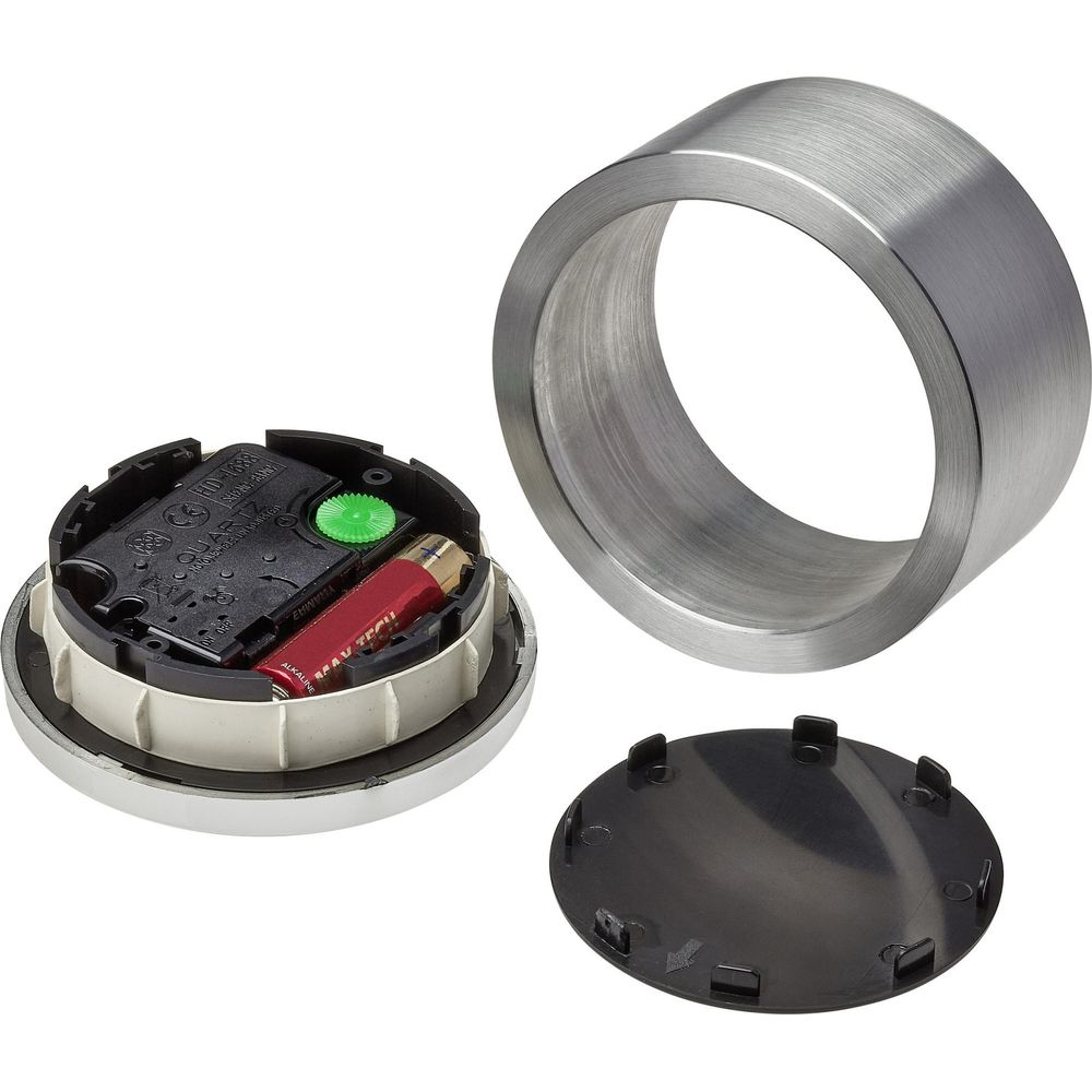 Movimento dell'orologio con batteria, anello metallico e coperchio cassa nero su sfondo bianco.