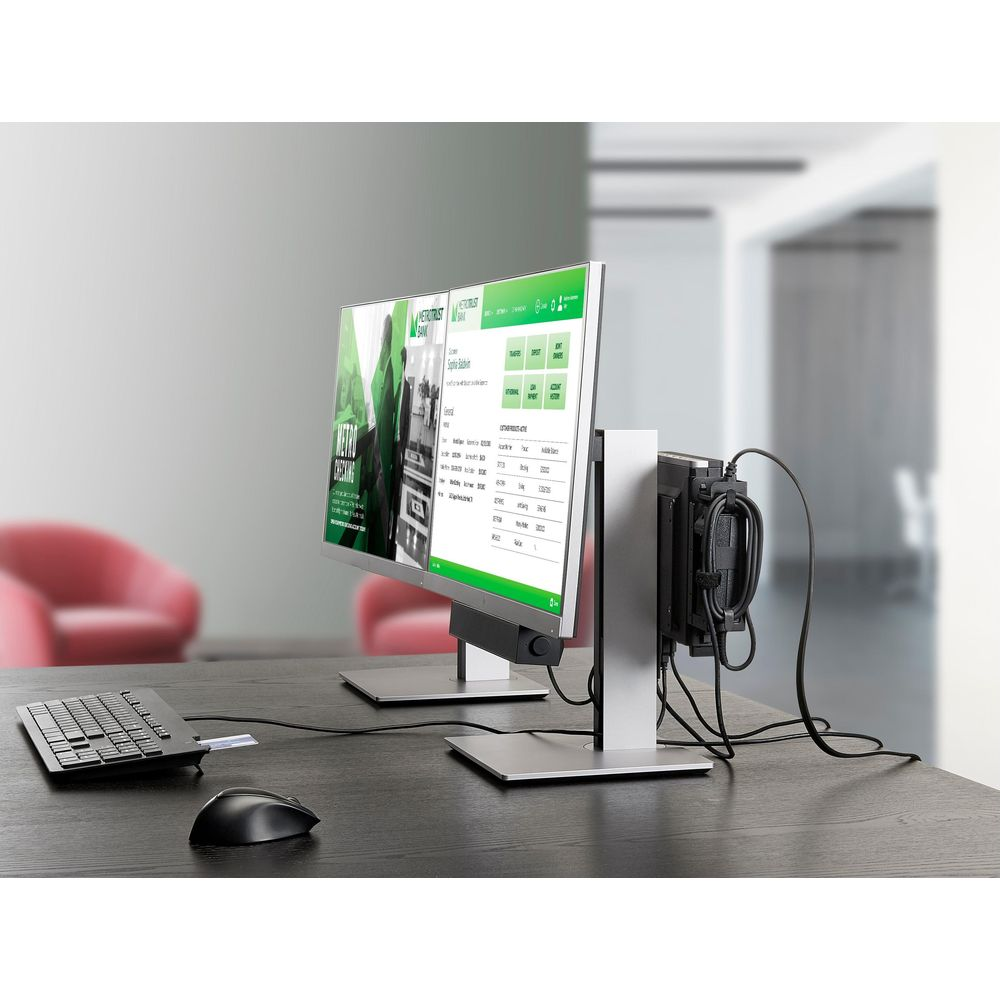 Una configuración de doble monitor en un escritorio con teclado y ratón. Una torre de ordenador está montada detrás.