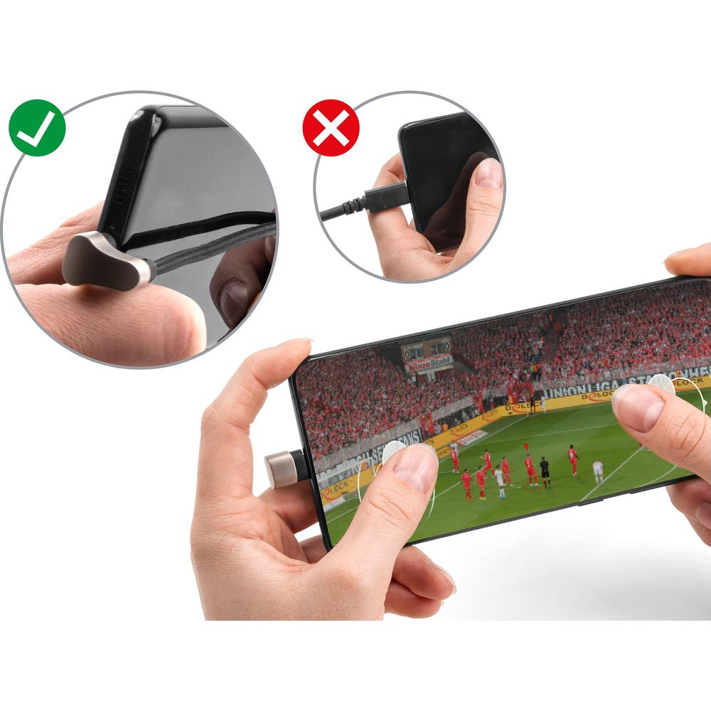 Una mano tiene un telefono che mostra una partita di calcio. Primo piano di un cavo a sinistra.