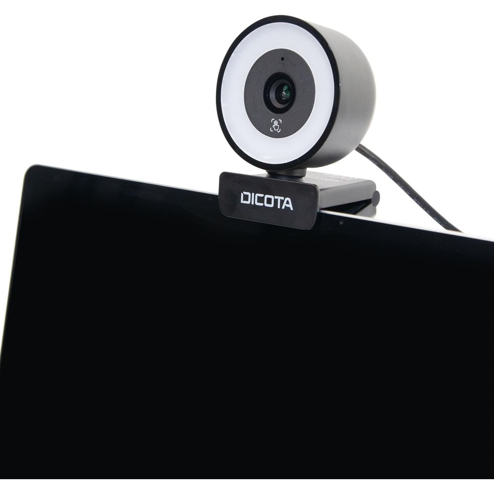 Una webcam Dicota nera con luce anulare bianca è agganciata allo schermo di un laptop.