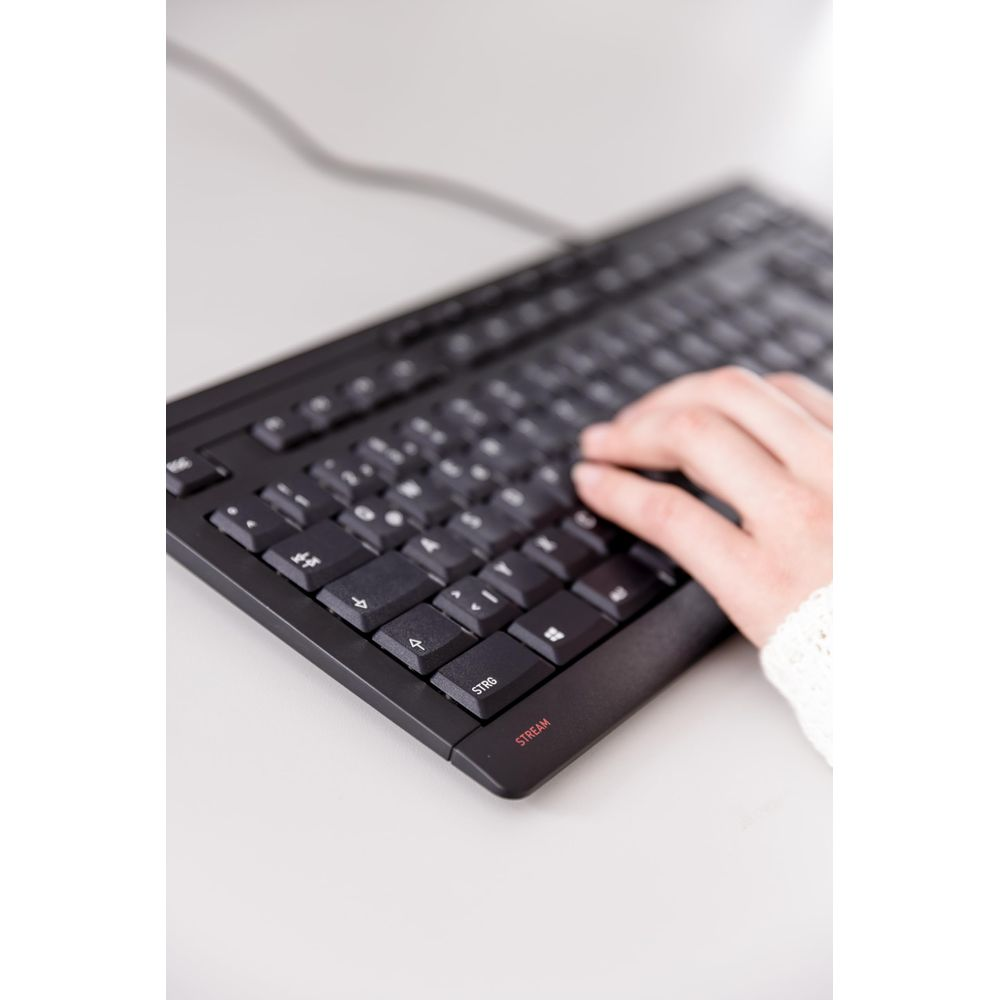 Eine Hand mit weißem Strickpullover tippt auf einer schwarzen Tastatur.