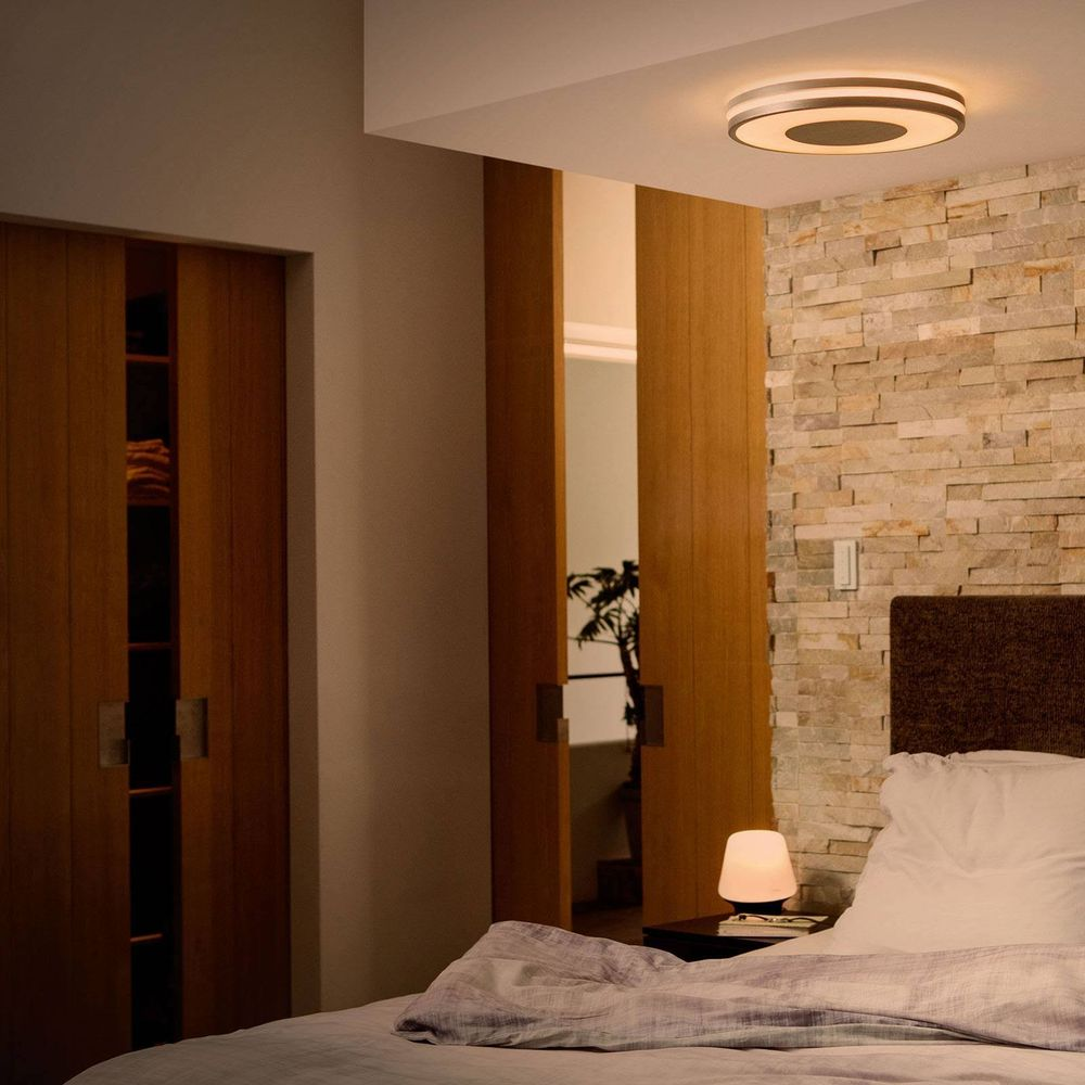 Ein Schlafzimmer mit Holztüren, Steinwand, Bett und Lampe.