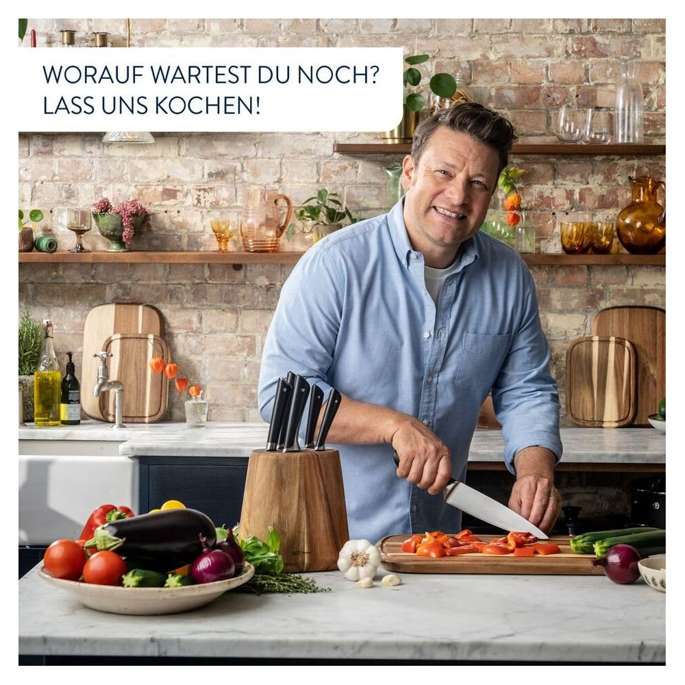 Jamie Oliver taglia i peperoni in una cucina con verdure e coltelli.