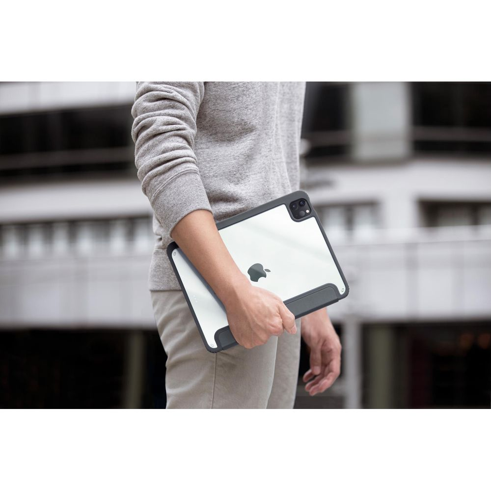 Kişi Apple logolu tablet tutuyor, gri sweatshirt, bej pantolon.