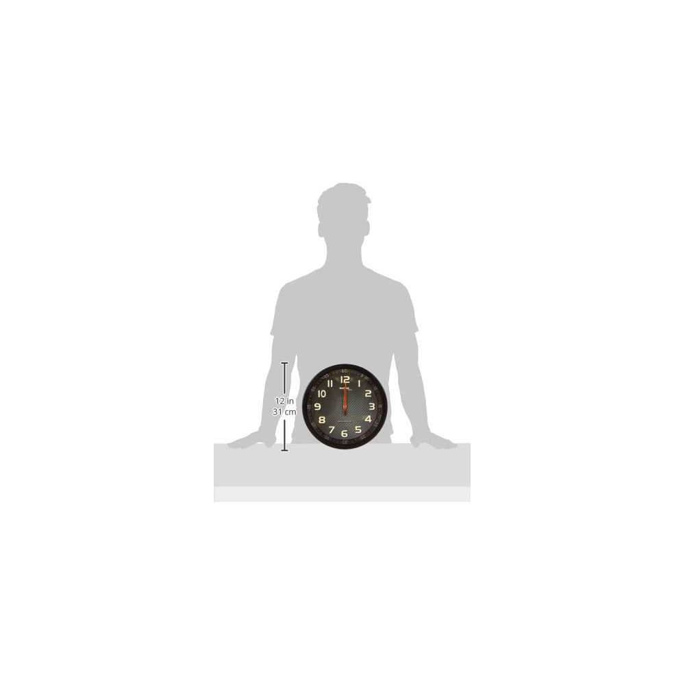 Ein Mann hält eine schwarze Wanduhr mit weißen Ziffern und Zeigern.