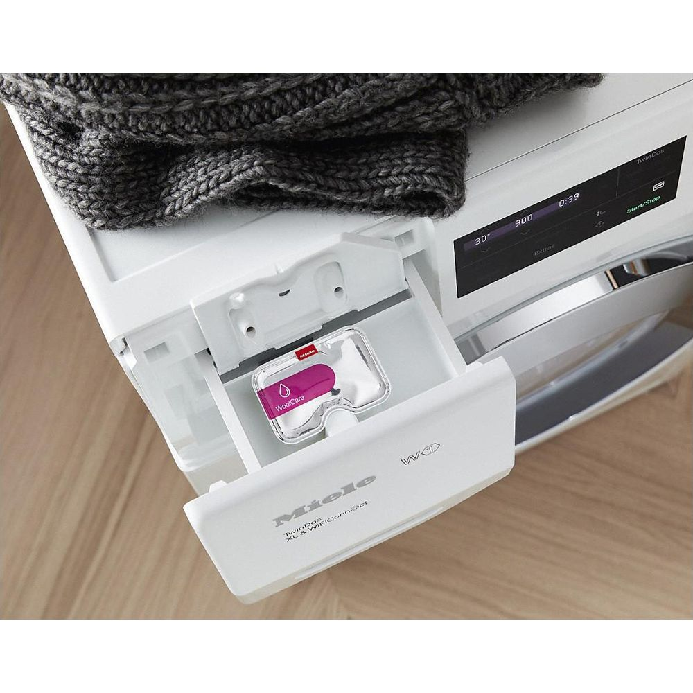 Eine Miele Waschmaschine mit einer Schublade für Waschmittel und einer Wollpflegekartusche.
