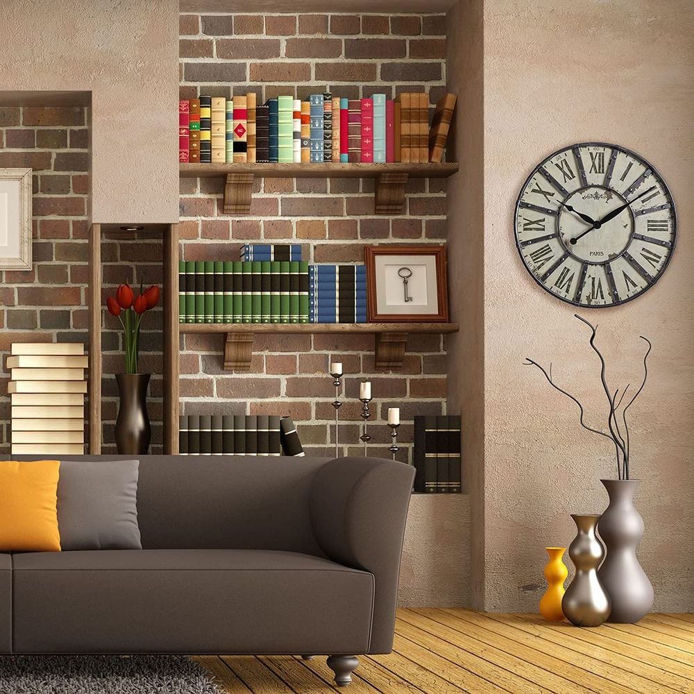 Ein Wohnzimmer mit Sofa, Büchern, einer Uhr und Vasen auf Holzboden.