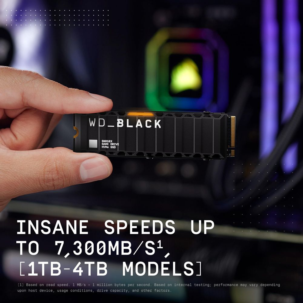 Dłoń trzyma WD_BLACK SN850X NVMe SSD, wentylator PC w tle.
