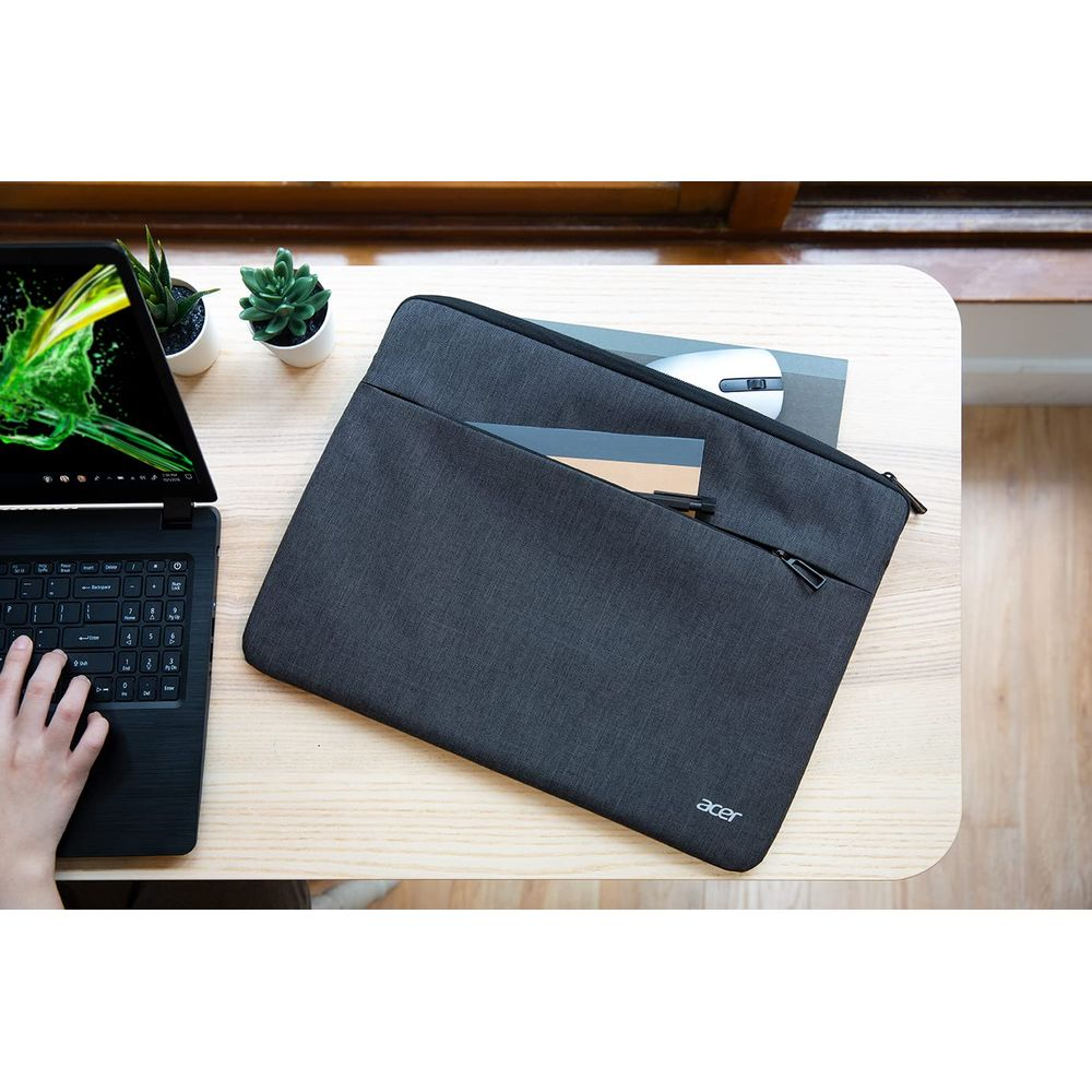 Un laptop con custodia, mouse e piante su un tavolo di legno.