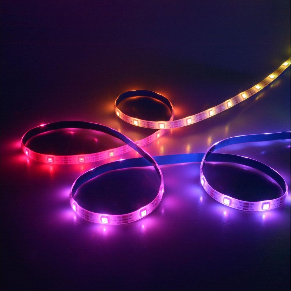 Strisce LED rosse, viola e gialle si illuminano su sfondo scuro.