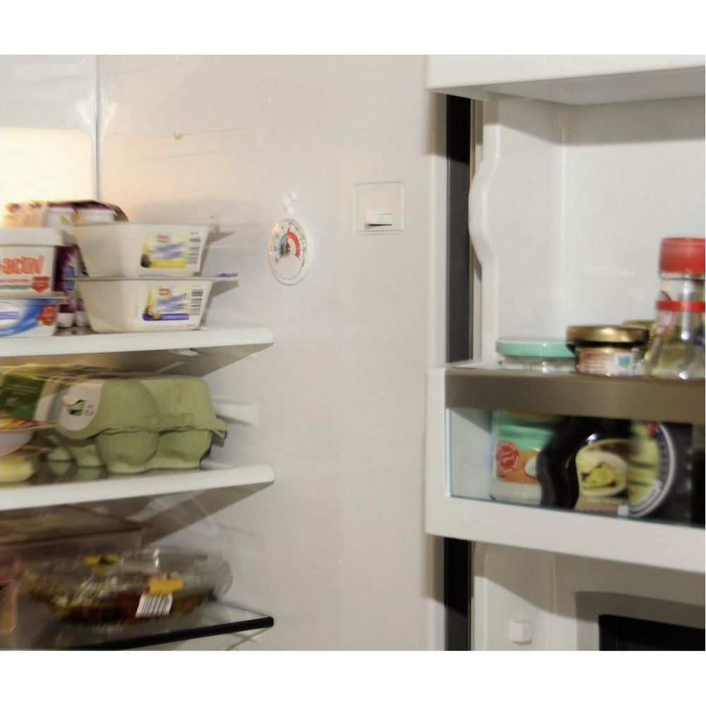Ein offener Kühlschrank mit Regalen voller Lebensmittel und einer Thermometeranzeige.