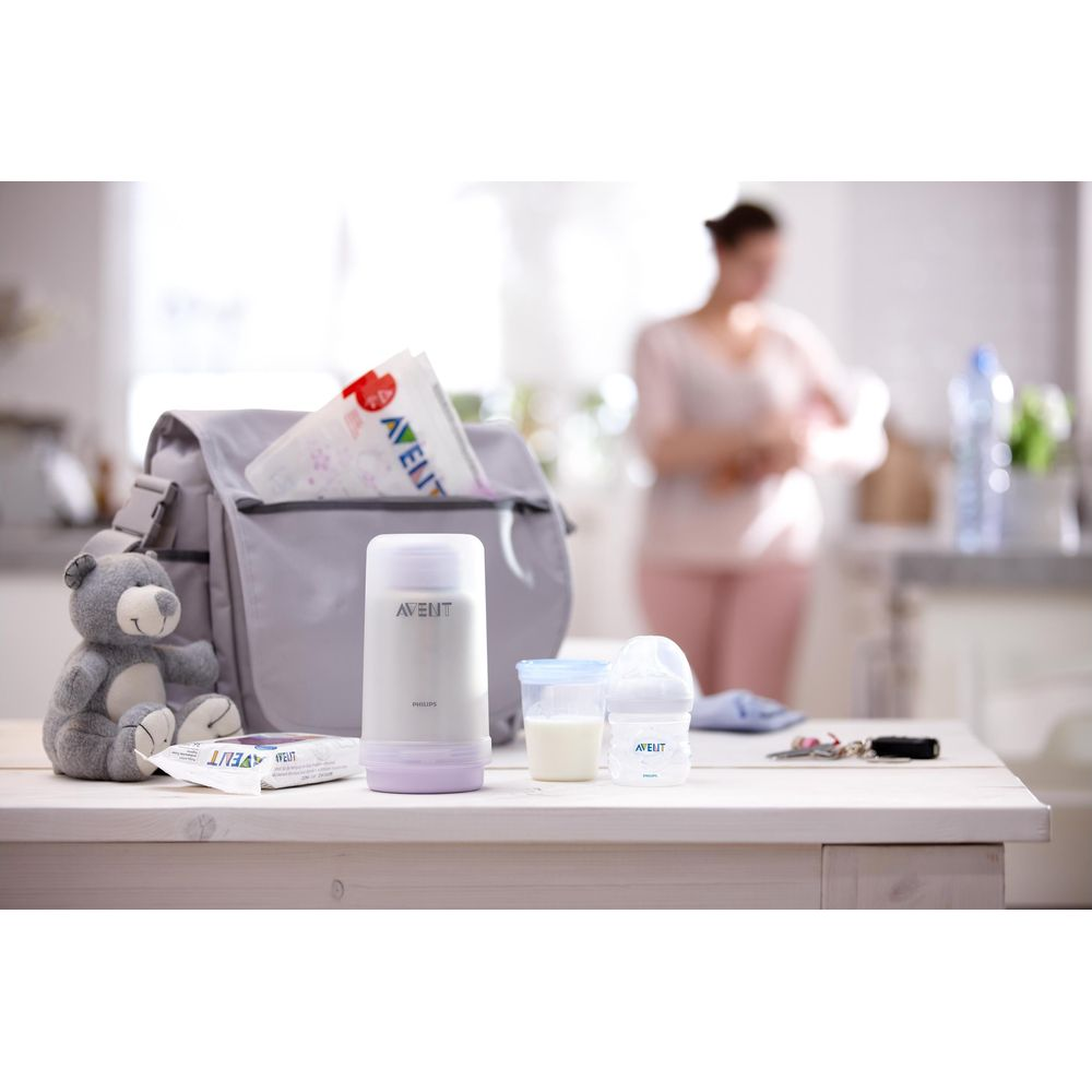 Grauer Teddy, Avent-Tasche, Thermoskanne, Fläschchen und Schlüssel auf einem Tisch.
