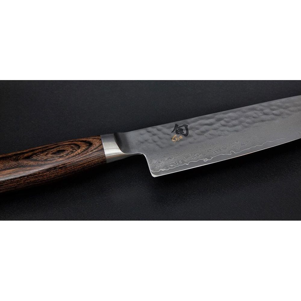 Un coltello da cucina affilato con manico in legno e motivo Damasco.