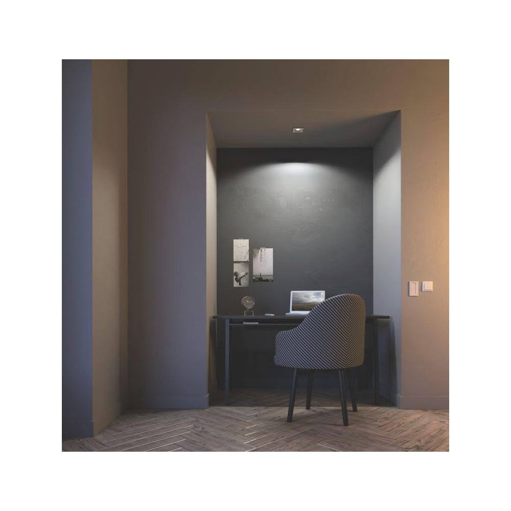 Un bureau avec ordinateur portable, chaise et tableaux dans une niche.