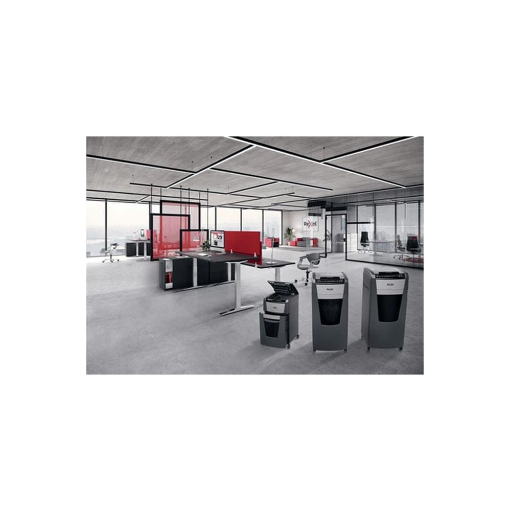 Modernes Büro mit Schreibtischen, Stühlen und drei Aktenvernichtern im Vordergrund.