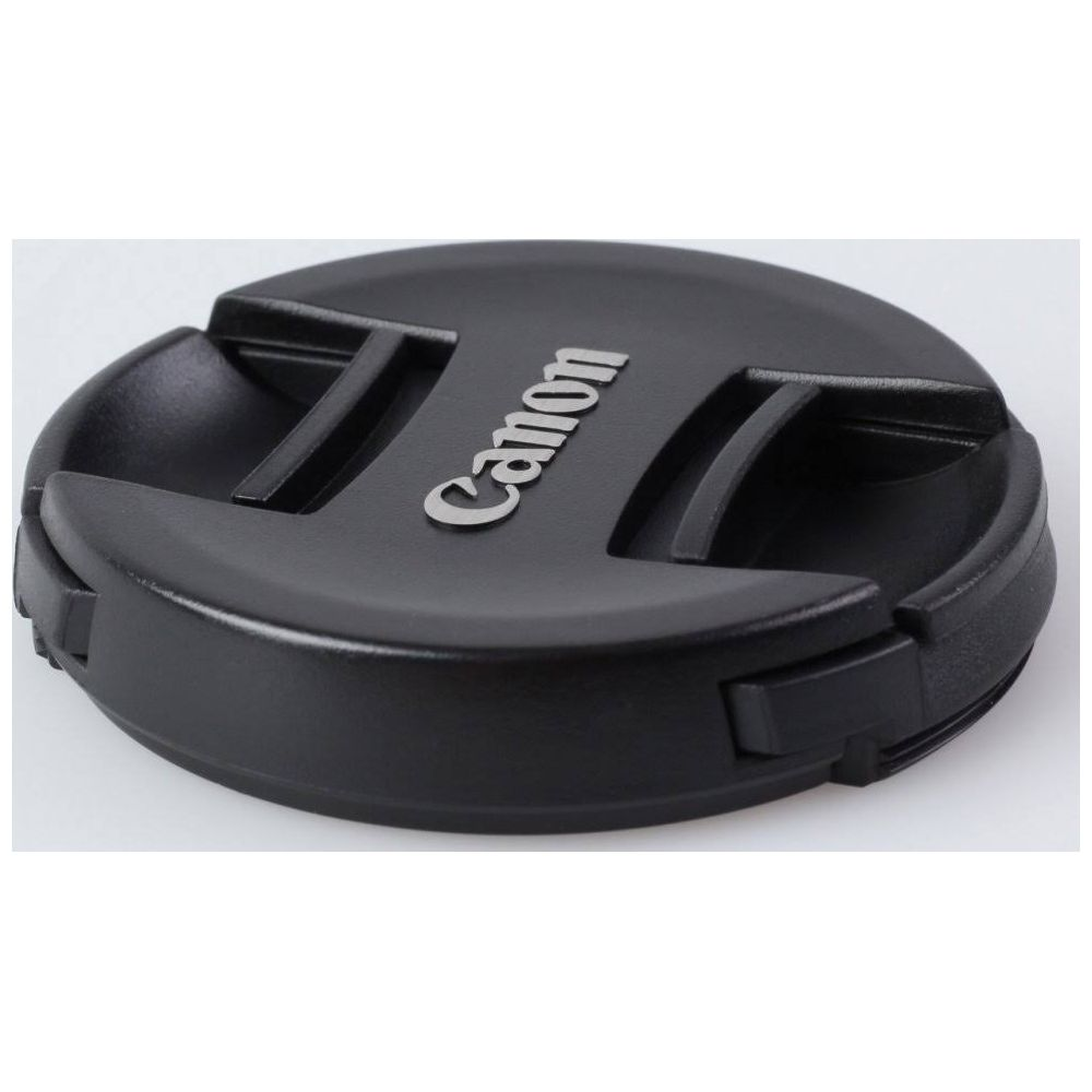 Czarna osłona obiektywu z srebrnym logo Canon, zbliżenie.