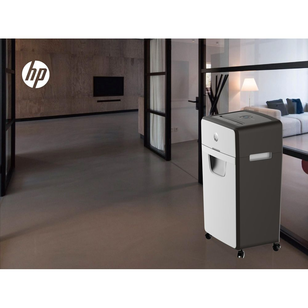 Un distruggi documenti HP si trova in un soggiorno moderno con divano e lampada.