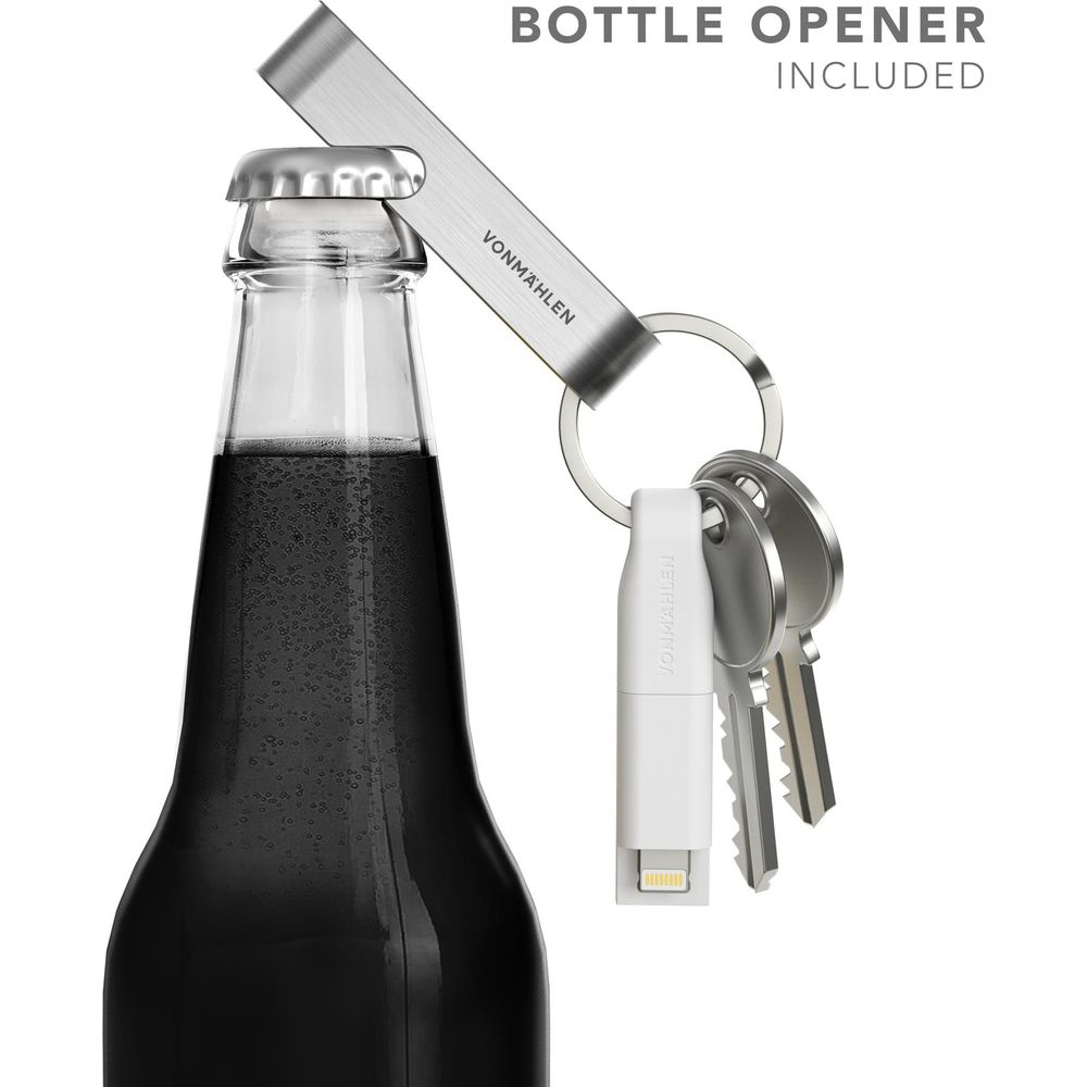Un décapsuleur en métal est attaché à un porte-clés avec des clés et un adaptateur blanc.